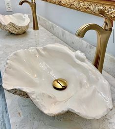 a bathroom sink with a gold faucet and marble counter top next to it