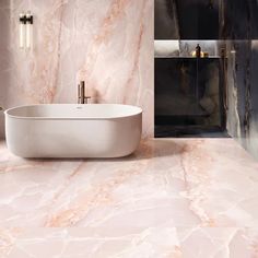 a bath tub sitting on top of a bathroom floor next to a sink and mirror