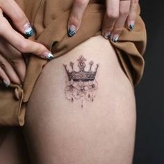 a woman's thigh with a crown tattoo on it