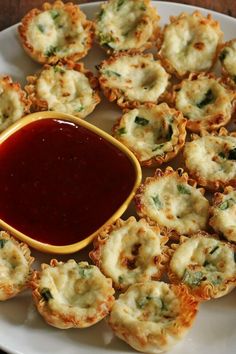 small appetizers on a white plate with ketchup and sauce in the middle