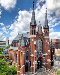 an old brick church with steeples on the roof and stairs leading up to it