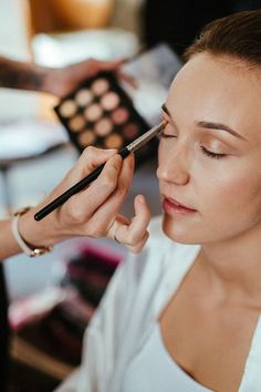 a woman is getting her make up done