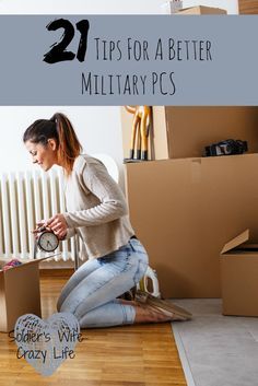 a woman sitting on the floor in front of boxes holding a clock