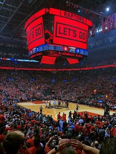 a basketball game is being played in an arena with red lights on the floor and fans