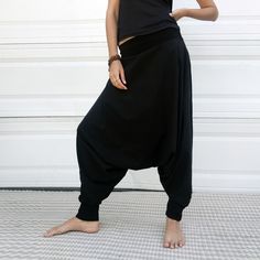 "Black Samurai Style Ninja Pants for Women and Men. This Stretch Cotton Harem Pants Fit Plus Size. -Unisex -Stretch -Flowing relaxed fit -Inner drawstring to secure the waist -2 side pockets Great for Yoga, Dance, Exercises, Meditations, Yoga Practice and beyond... Materials: black color cotton blend (90% cotton 10% lycra). Fabric for this pair were bought in Fashion District, LA and the pant was made in one of the studios in Los Angeles, CA. Measurements: Fits: S, M, M/L -Length: 41\" (~102 cm) Black Hip-length Bottoms For Yoga, Black Stretch Harem Pants For Loungewear, Stretch Black Harem Pants For Loungewear, Black Cotton Sweatpants For Yoga, Casual Black Yoga Bottoms, Black Harem Pants For Loungewear With Loose Fit, Black Wide Leg Sweatpants For Yoga, Black Wide-leg Sweatpants For Yoga, Black Harem Pants For Loungewear