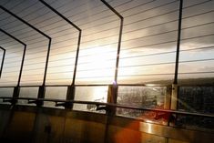 the sun is shining through some blinds on top of a building with water in the background