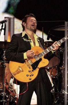 a man playing an electric guitar on stage