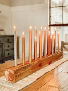 a wooden table topped with lots of lit candles