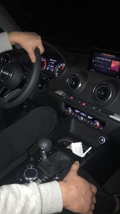 the man is driving his car at night with no one in sight on the steering wheel