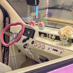 the interior of a car with pink trim and flowers in vases on the dash board