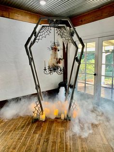 a room with some candles on the floor and a spider web decoration hanging from the ceiling