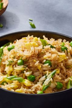 a bowl filled with rice and asparagus on top of a table