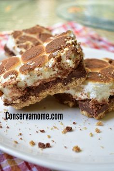 two pieces of chocolate and marshmallow ice cream sandwich on a white plate with a checkered table cloth