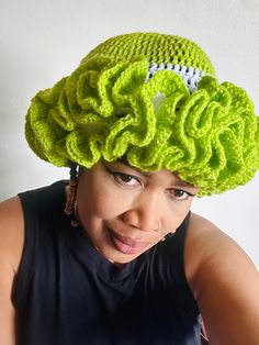 a woman wearing a green crocheted hat with a football on it's brim