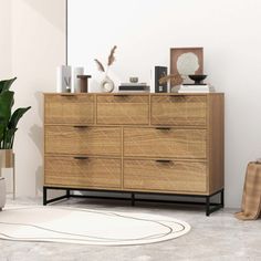 a wooden dresser sitting next to a potted plant