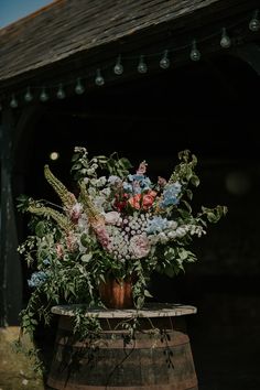 a wooden barrel with flowers and greenery in it