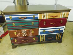 a multicolored chest of drawers sitting on top of a floor