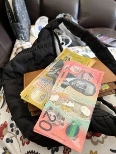 a purse filled with money sitting on top of a couch next to a pile of other items