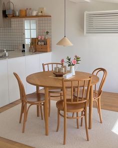 a dining table with four chairs around it