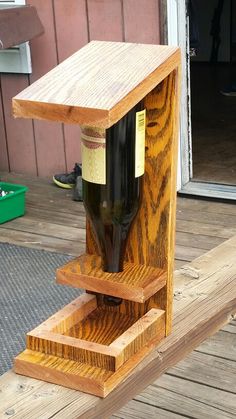 a wine bottle holder made out of wooden planks on a deck with a door in the background