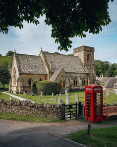 a red phone booth sitting in front of a church