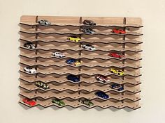 a wall mounted wooden rack with toy cars on it