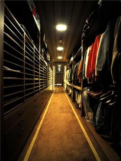 a long hallway with lots of clothes on shelves