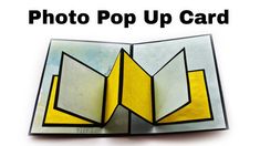 an open book with the words photo pop up card in black and yellow on it