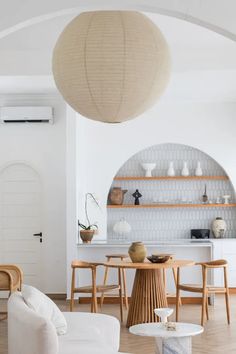 a living room filled with furniture and a large light fixture hanging over the top of it