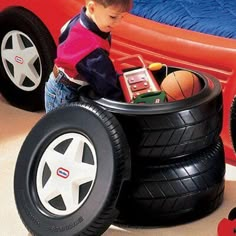 a young boy playing with toys in a toy car bed