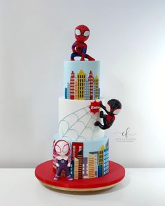 a three tiered cake with spiderman on top