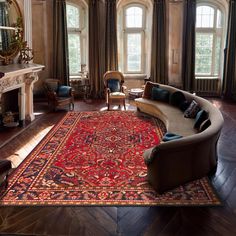 a living room filled with furniture and a large rug on top of a hard wood floor