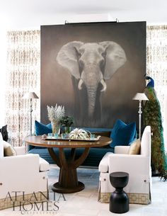 a living room filled with furniture and a large painting on the wall above it's head