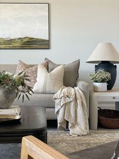 a living room filled with furniture and a painting on the wall