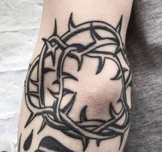 a person with a tattoo on their arm and hand is holding an object in the shape of a circle