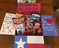 a box filled with snacks and notes on top of a wooden table next to a flag