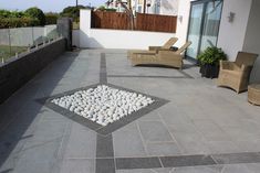 an outdoor patio with chairs and gravel on the ground