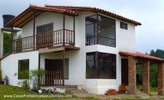 a white house with brown trim and balconies