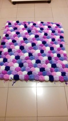 a pink, blue and white rug on the floor