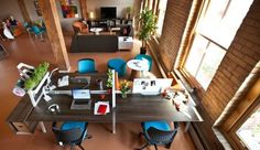 an aerial view of a room with tables, chairs and laptops on it's desk