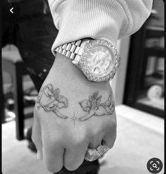 a black and white photo of a person with a wrist tattoo