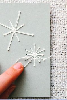 someone is stringing the snowflakes on a card