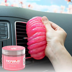 a person is holding a pink doughnut in their hand next to a car radio