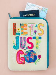 a passport case with the words let's just go written on it and flowers