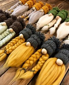 several different colored braids are laid out on a wooden table with other items in the background