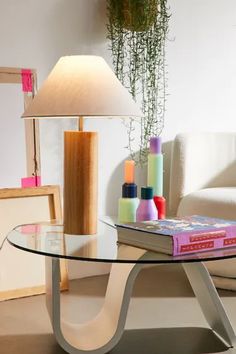 a glass table with a book and lamp on it