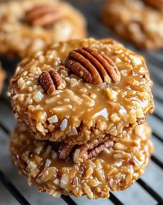 three pecan cookies stacked on top of each other, with one being drizzled with caramel