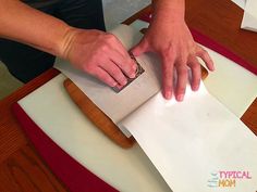 a person cutting paper on top of a table