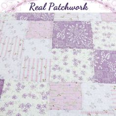 a purple and white patchwork quilt with flowers on it