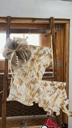 an unfinished piece of wood sitting on top of a wooden shelf next to a window